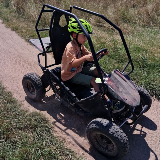 Maximilian mit Helm im Buggy auf einem Feldweg